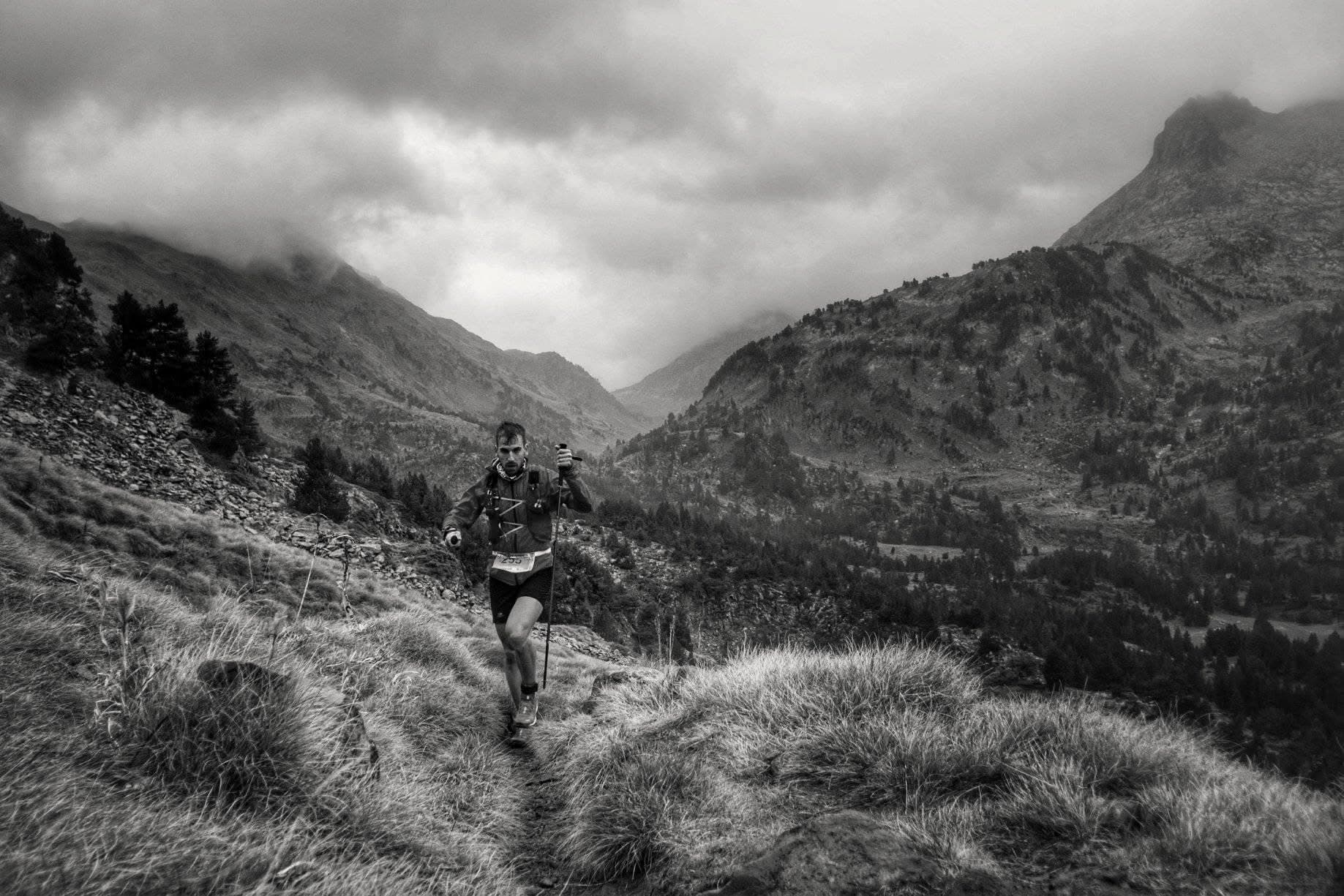 Lorenzo García en un sendero de alta montaña bajo nubes.